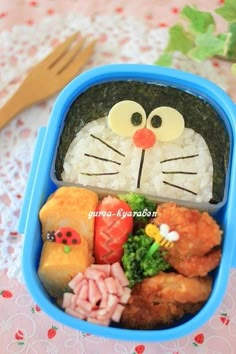 a bento box with rice, meat and vegetables in the shape of a cat