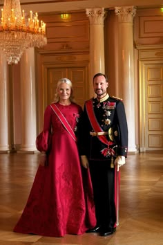 a man and woman in formal dress standing next to each other