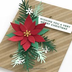 a christmas card with a poinsetti on it and a tag that says wishing you a very merry christmas