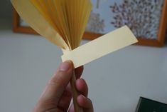 a person holding up a piece of yellow paper