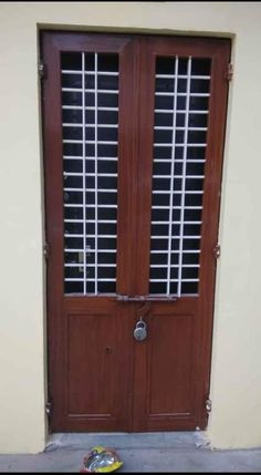 a pair of shoes sitting on the ground in front of a door with shutters