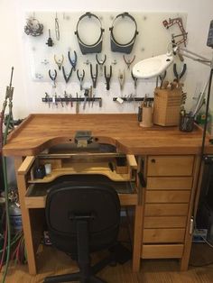 a workbench with lots of tools hanging on the wall