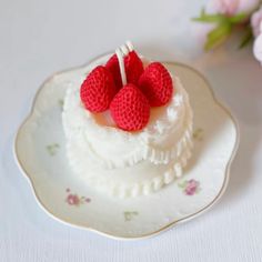 two raspberries sitting on top of a white cake