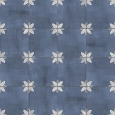 a blue and white tiled wall with flowers on the bottom half, in an abstract pattern