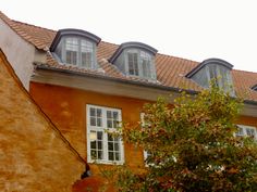 an orange building with dormers and three windows