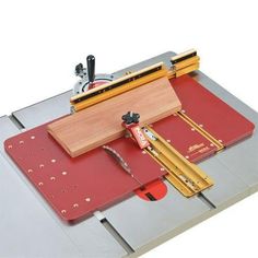 a machine that is sitting on top of a piece of red paper and some tools