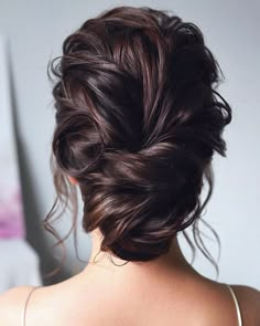 the back of a woman's head with her hair in a low updo