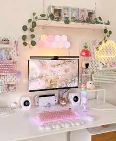 a white desk with a computer on top of it and various accessories around the perimeter