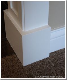 the corner of a room with carpeting and a white door on top of it