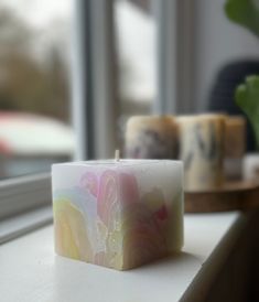 a candle sitting on top of a counter next to a window