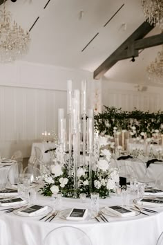 the tables are set with white flowers and candles