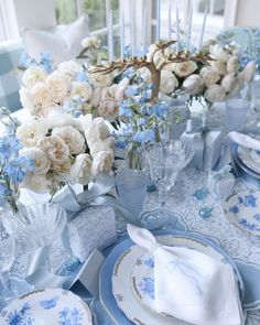 the table is set with blue and white flowers