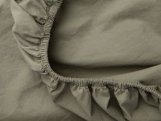 an unmade bed with ruffles on it