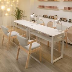 a white table and chairs in a room with lights on the wall above it, along with bookshelves