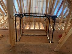 the inside of a house with wooden framing and metal frameworks on the floor in front of it