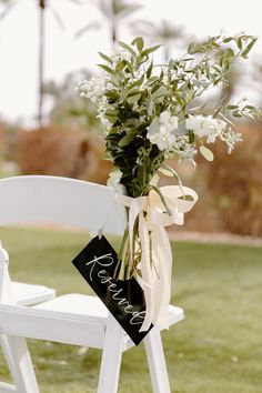 a bouquet of flowers sitting on top of a white chair in front of a palm tree