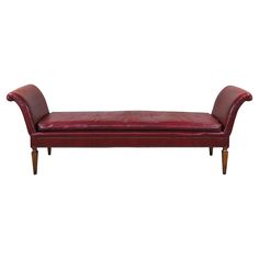 a red leather bench sitting on top of a wooden frame