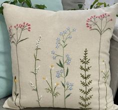 an embroidered pillow with flowers on it