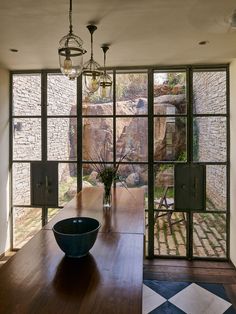 a dining room table with a large bowl on it's centerpiece in front of an open window