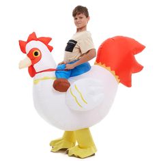 a boy riding on an inflatable chicken costume