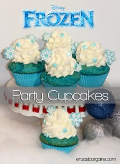 frozen party cupcakes with white frosting and blue icing on top, surrounded by snowflakes