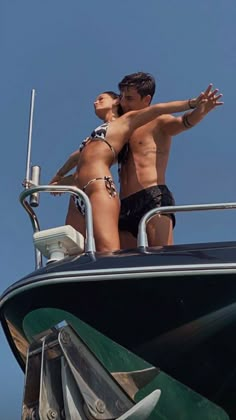 two people standing on the back of a boat