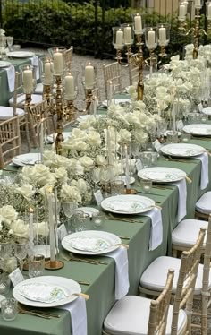 a long table is set with white flowers and candles