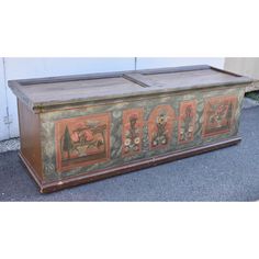 an old wooden chest with paintings on the front and side panels painted in different colors