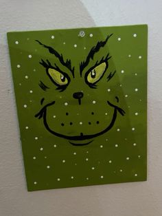 a close up of a green sign with a cat's face drawn on it