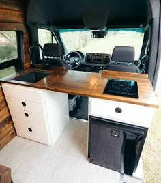 the interior of a camper with an oven and sink