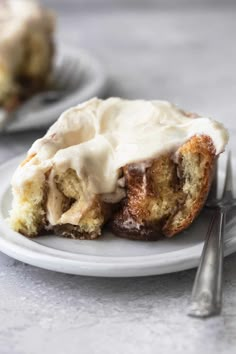 a white plate topped with cinnamon roll covered in icing