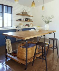 a kitchen with blue cabinets and an island in front of the countertop is surrounded by stools