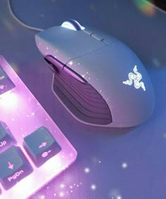 a computer mouse sitting next to a keyboard on top of a purple surface with stars