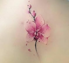 a pink flower on the back of a woman