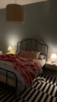 a bed room with a neatly made bed and two lamps on either side of the bed