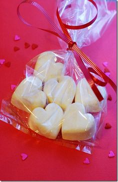 small heart shaped marshmallows wrapped in cellophane on a pink background