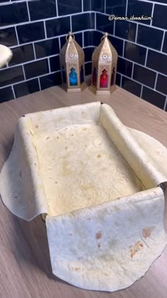 an uncooked tortilla sitting on top of a counter next to a candle