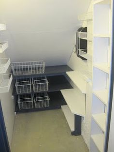 an empty room with shelves and bins in it