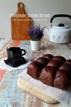 chocolate raisin bread is sitting on a table next to a cup of coffee and a teapot