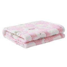 a pink and white blanket sitting on top of a bed