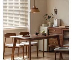 a dining room table and chairs in front of a window with blinds on the windowsill