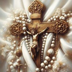 the cross is adorned with pearls, beads and a crucifix in gold