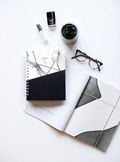 an open notebook sitting on top of a table next to eyeglasses and other items