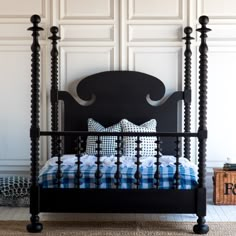 a black bed frame with blue and white pillows