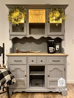 a gray hutch with wreaths on the top