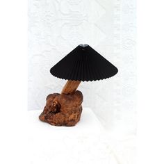 a small black lamp sitting on top of a wooden table next to a white wall