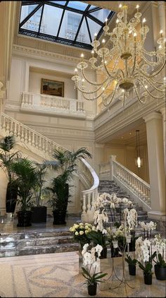 an elegant staircase with chandelier and flowers