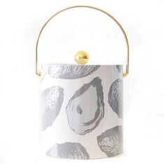 a white and black flower pot with gold handles on a white background that is decorated with flowers