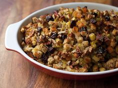 a casserole dish filled with stuffing and raisins on a wooden table