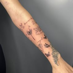 a woman's arm with tattoos on it and flowers in the middle is shown